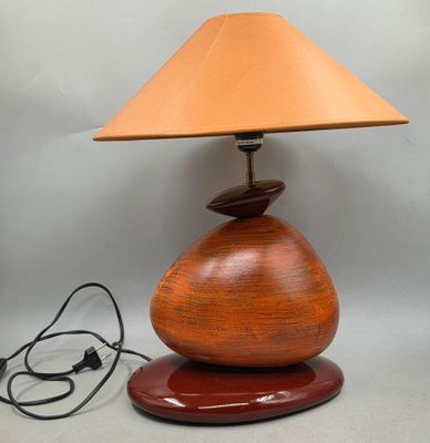 une image représentant une lampe avec un pied en bois et un abat-jour marron