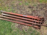 three old rusted metal poles laying on the ground in the grass