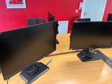 two computer monitors on a desk with a keyboard and mouse