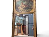 un grand miroir orné d'une peinture, dans une pièce