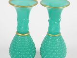 paire de vases en verre vert avec des bordures dorées sur fond blanc