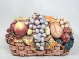 une figurine représentant une corbeille de fruits posée sur une table