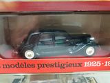 a black toy car in a red box on display