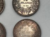 four different types of coins are shown on a white surface