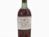 une bouteille de vin posée sur une surface blanche