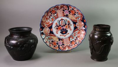 three vases and a plate sitting on a table
