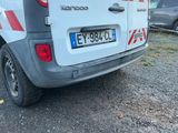 une camionnette blanche avec une bande rouge garée sur un parking