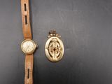 une image représentant une montre-bracelet et un bracelet de montre orné du portrait d'une femme