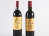 two bottles of wine sitting next to each other on a white surface