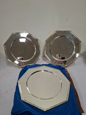 deux assiettes en argent et une serviette bleue sur une table