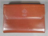 an image of a brown leather wallet with a maple leaf on the front