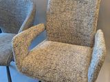 two chairs sitting next to each other on a white surface
