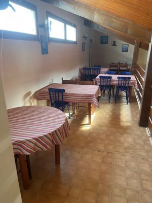 une pièce équipée de tables et de chaises, avec une verrière