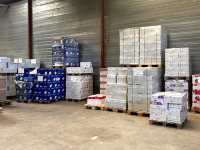 many pallets of boxes in a warehouse with pallets on them