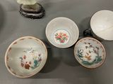 four bowls and two cups sitting on a table