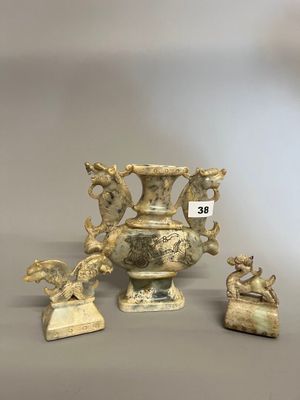 trois vases et statues anciens posés sur un socle gris