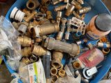 a blue bowl full of plumbing items on the ground