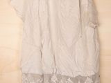 white dress hanging on a hanger on a wooden wall