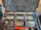 une boîte à outils contenant des outils, posée sur le sol