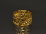 a gold ring with an eagle on it sitting on top of a black surface