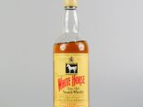 une photo d'une bouteille de whisky White Horse posée sur une table