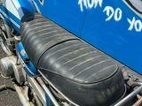 une moto bleue garée sur le bord de la route