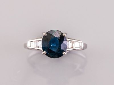un gros plan sur une bague sertie d'un saphir bleu et de diamants
