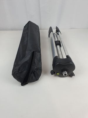 un gros plan sur un trépied d'appareil photo et un sac posés sur une surface blanche