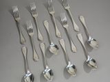 six forks and six spoons on the table