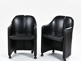 une paire de fauteuils en cuir noir sur roulettes, sur fond blanc