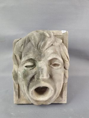 une sculpture en pierre représentant le visage d'un homme, la bouche ouverte