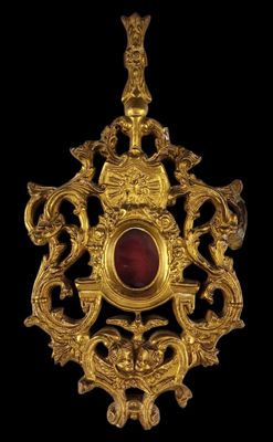 une image représentant un pendentif en or et en grenat sur fond noir