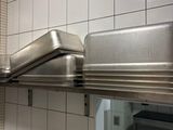 a stainless steel shelf in a kitchen with a microwave on it