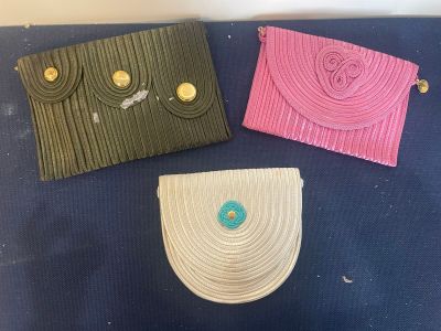 three purses are lined up on a blue surface with buttons