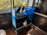 a black and white cat sitting on top of a blue cart