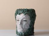 un gros plan sur une sculpture en céramique représentant le visage d'une femme