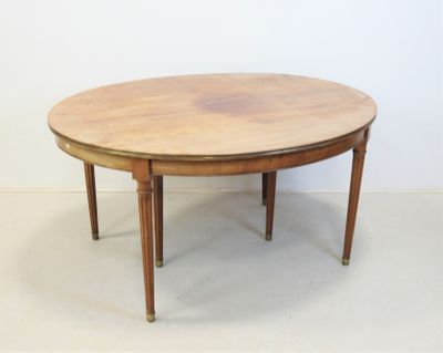 une table ronde avec un plateau en bois posée sur un sol blanc