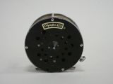 a close up of a fishing reel on a white surface