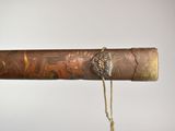 a long wooden stick with a metal handle on a string