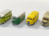 quatre petits bus alignés en rang sur une surface blanche