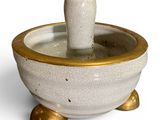 a small white bowl with a gold rim on a white surface