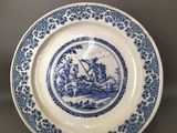 a blue and white plate with an image of a boat on it