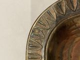 a close up of a metal plate with a design on it