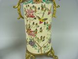 a vase with a bird and flowers on it on a stand
