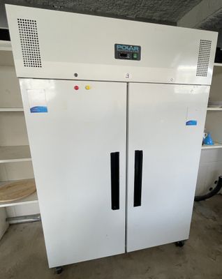 a white freezer that is in the middle of a room
