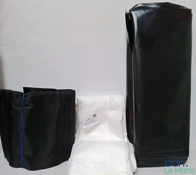 un sac noir et un pantalon blanc posés sur une table