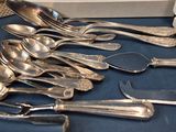 a lot of silver spoons and forks on a table