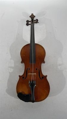 un vieux violon accroché au mur, avec l'ombre d'une personne derrière lui