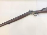 a rifle with a wooden barrel and a wooden barrel on a table