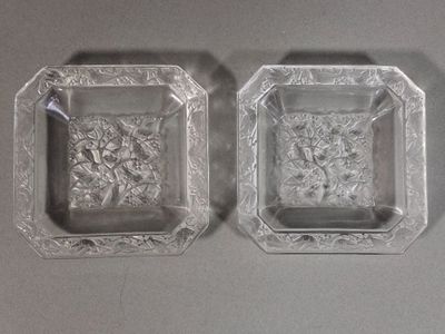une paire de cendriers en verre, chacun orné de motifs floraux